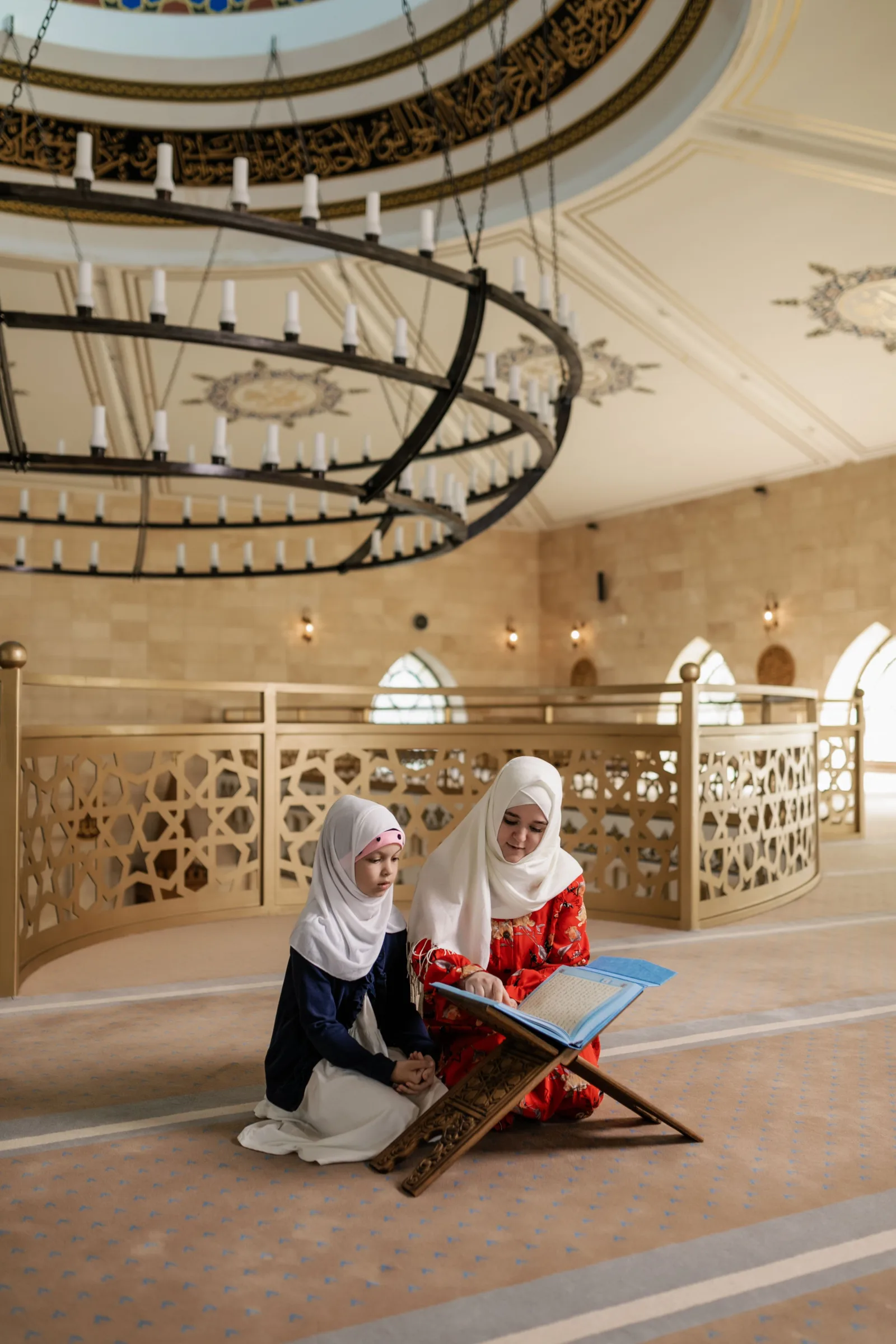 A Muslim mother in full hijab reading the Quran with her daughter